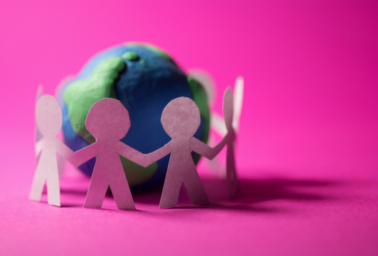 Bu görsel pembe zeminin üzerine oyun hamuru ve kağıtlarla yapılmış üç boyutlu bir kolaj. Görselin solunda oyun hamurundan bir dünya ve bu dünyayı el ele tutuşarak çevreleyen beyaz kağıttan insanlar yeralıyor.